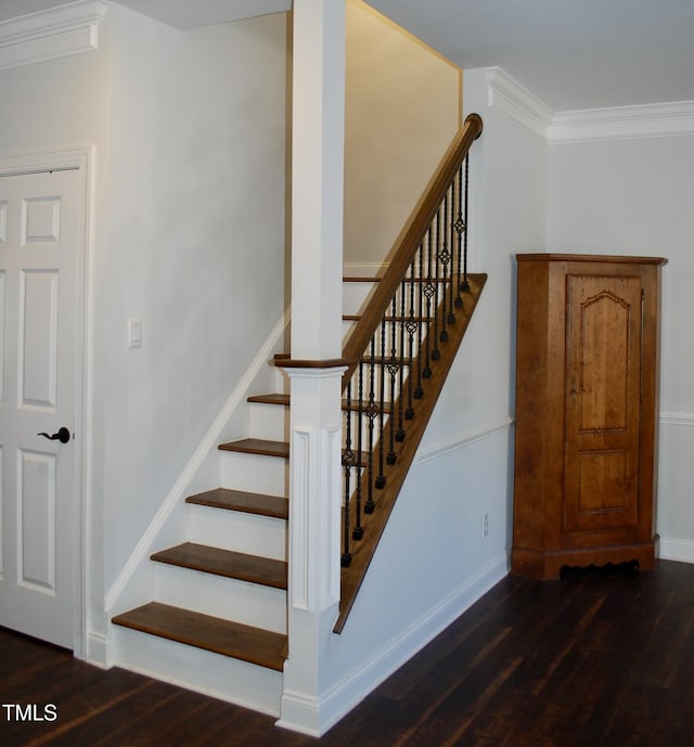 stairway with baseboards, wood finished floors, and ornamental molding