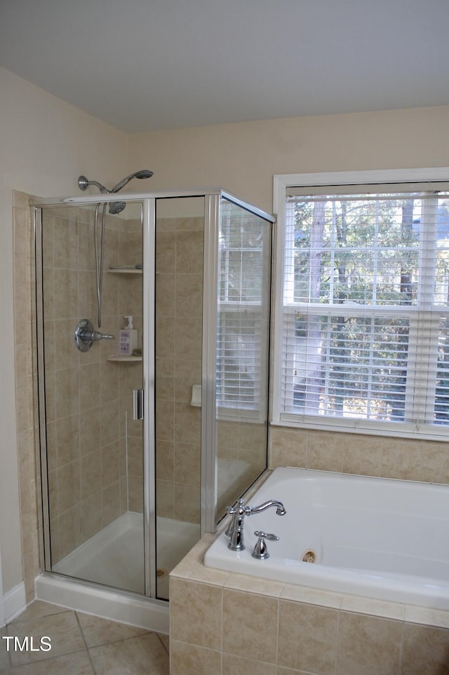 bathroom featuring tile patterned floors, a shower stall, and a garden tub