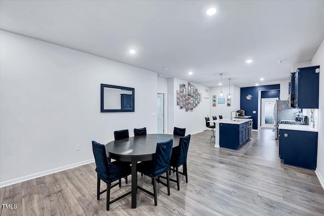 dining space featuring sink and light hardwood / wood-style floors