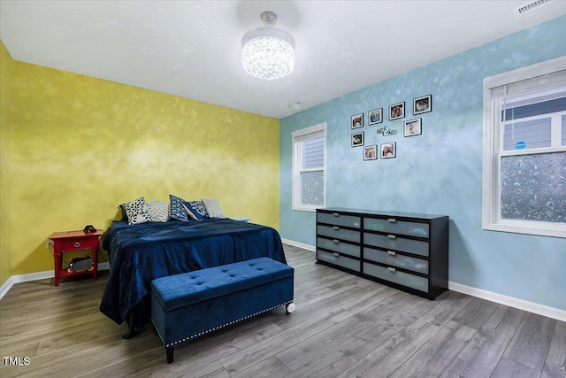 bedroom with wood-type flooring and a chandelier