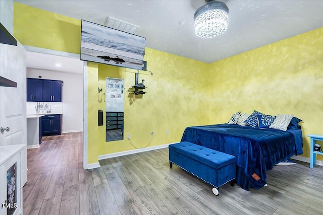 bedroom featuring light hardwood / wood-style floors and an inviting chandelier