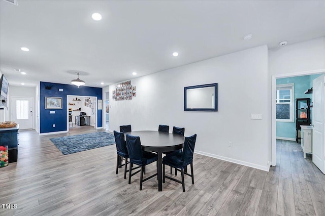 dining area with a wealth of natural light and light wood-type flooring