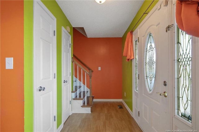 foyer with a textured ceiling and light wood-type flooring