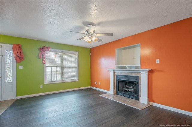 unfurnished living room with a fireplace, a textured ceiling, dark hardwood / wood-style flooring, and ceiling fan