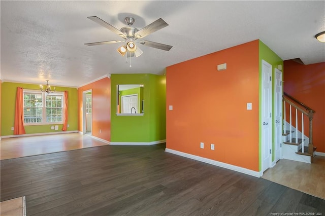 unfurnished living room featuring ceiling fan with notable chandelier, crown molding, dark hardwood / wood-style flooring, and a textured ceiling