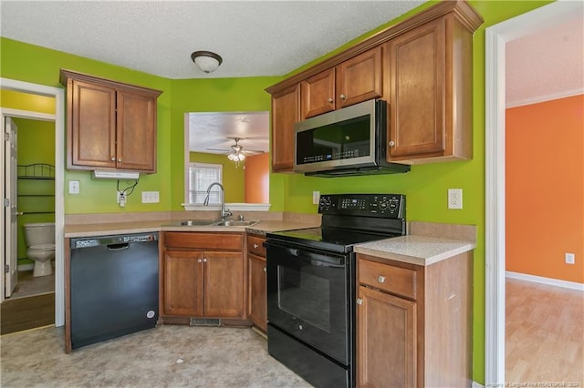 kitchen with light hardwood / wood-style flooring, sink, black appliances, a textured ceiling, and ceiling fan