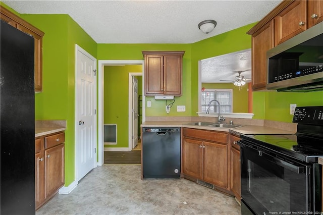 kitchen featuring black appliances, sink, ceiling fan, and a textured ceiling