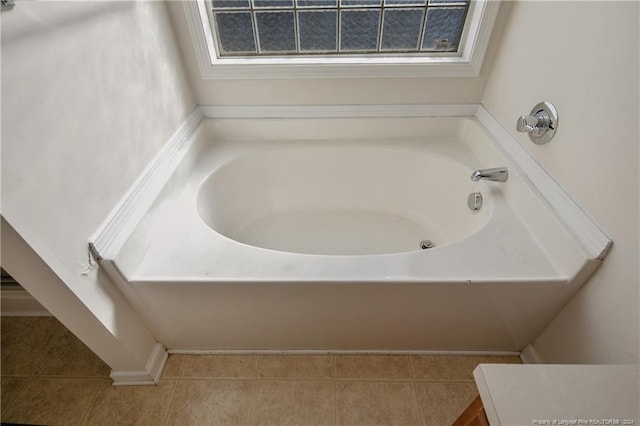 bathroom with a tub to relax in, tile patterned flooring, and a healthy amount of sunlight