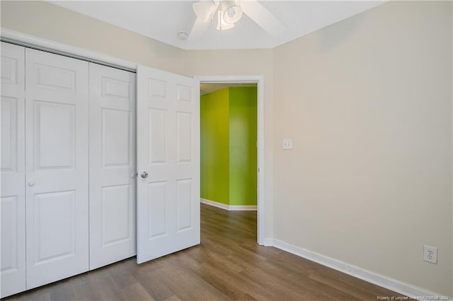 unfurnished bedroom with ceiling fan, a closet, and wood-type flooring