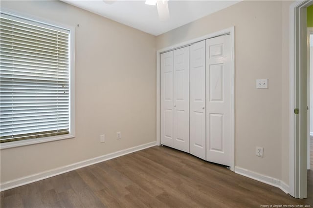 unfurnished bedroom with ceiling fan, a closet, and dark hardwood / wood-style floors