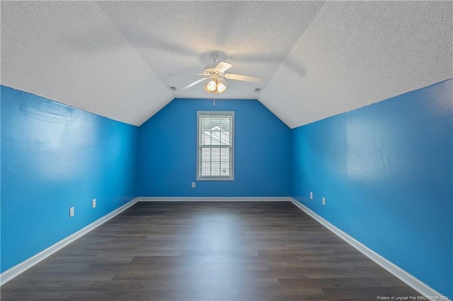 bonus room featuring lofted ceiling, ceiling fan, dark hardwood / wood-style floors, and a textured ceiling