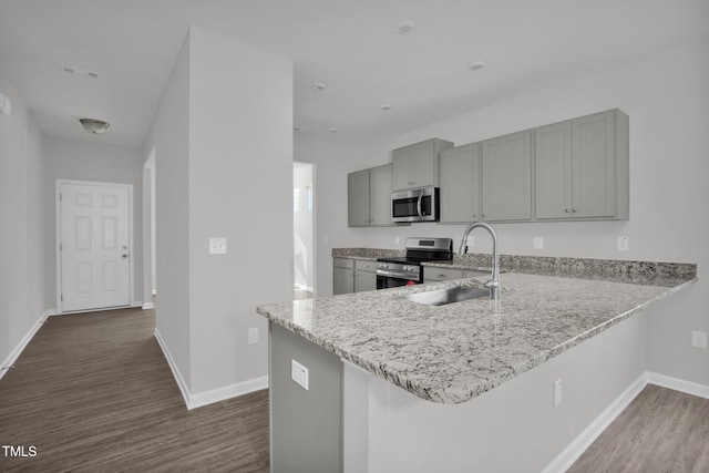 kitchen featuring gray cabinetry, sink, dark hardwood / wood-style floors, kitchen peninsula, and appliances with stainless steel finishes