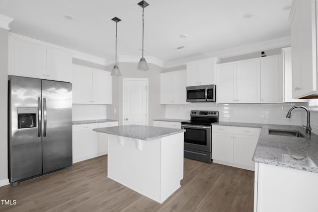 kitchen featuring white cabinetry, a center island, sink, hanging light fixtures, and stainless steel appliances