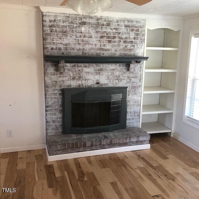 interior details featuring a fireplace, ornamental molding, and hardwood / wood-style flooring