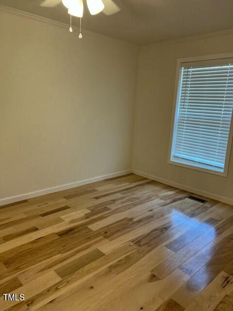 spare room featuring light wood-type flooring, ceiling fan, and crown molding