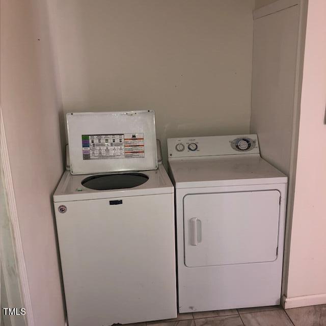 washroom with washing machine and clothes dryer and light tile patterned floors