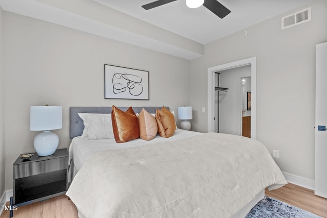 bedroom featuring ceiling fan, wood-type flooring, and a spacious closet