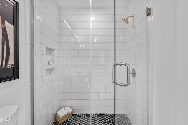 bathroom featuring an enclosed shower and toilet