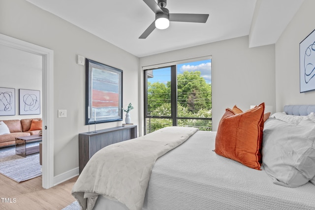 bedroom with ceiling fan, light wood-type flooring, and radiator