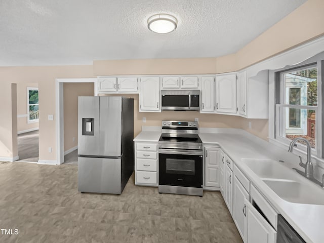 kitchen featuring sink, white cabinets, a textured ceiling, and appliances with stainless steel finishes