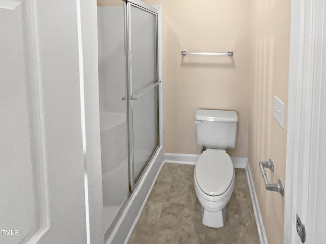 bathroom with toilet and a shower with door