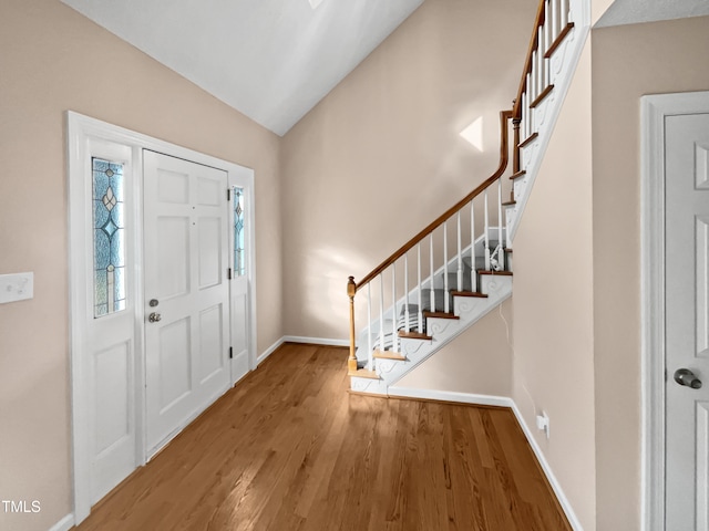 foyer entrance featuring lofted ceiling and wood-type flooring