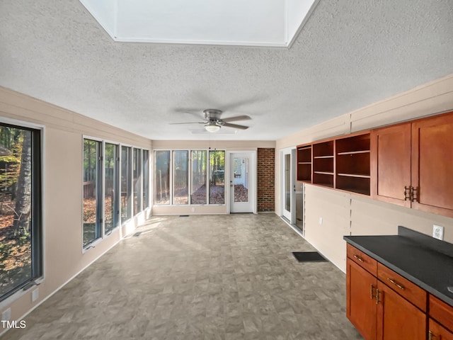 unfurnished sunroom with ceiling fan and a healthy amount of sunlight