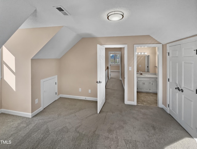 bonus room with light carpet, vaulted ceiling, and sink