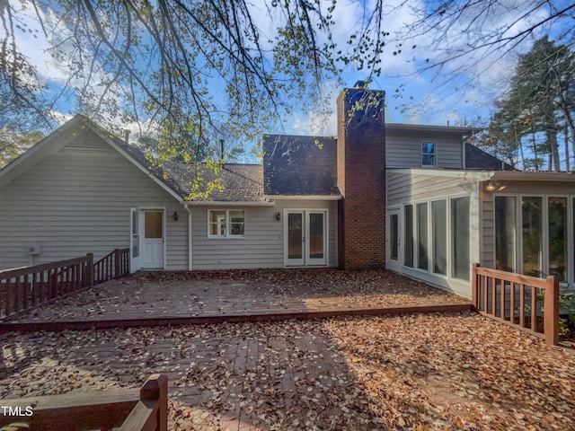 rear view of property with a wooden deck and a sunroom