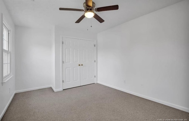 spare room with ceiling fan and carpet