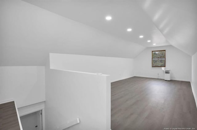 additional living space featuring dark hardwood / wood-style flooring and vaulted ceiling