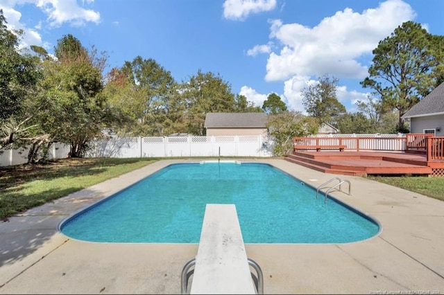 view of swimming pool with a diving board and a wooden deck