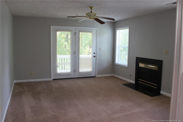 unfurnished living room with ceiling fan, carpet, and a textured ceiling