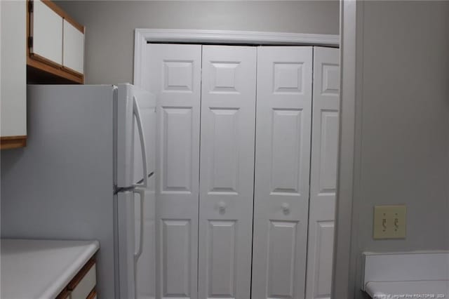 kitchen featuring white cabinets and white fridge