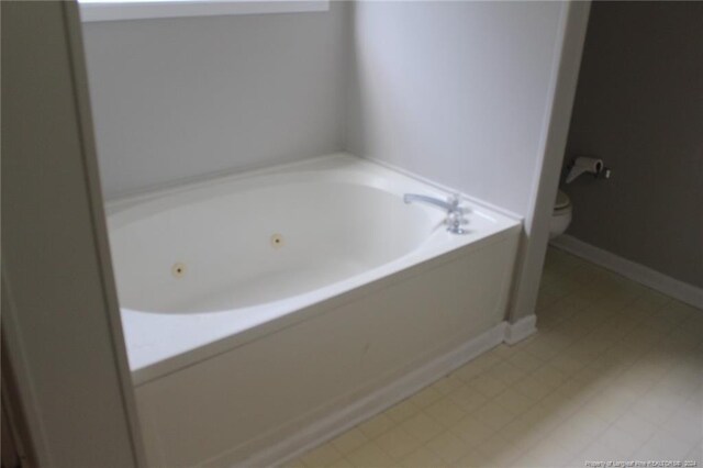 bathroom featuring a tub to relax in and toilet