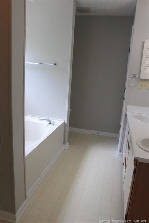 bathroom featuring vanity and a tub to relax in