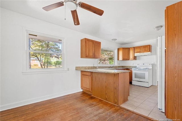 kitchen with kitchen peninsula, ceiling fan, light hardwood / wood-style floors, and white appliances