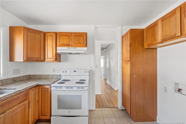 kitchen featuring electric stove, light tile patterned floors, and light stone countertops