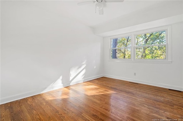 empty room with hardwood / wood-style flooring and ceiling fan