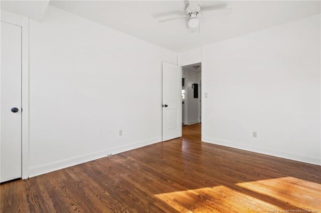 unfurnished room with ceiling fan and dark wood-type flooring