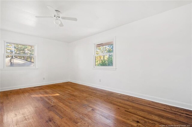 unfurnished room featuring hardwood / wood-style floors, a wealth of natural light, and ceiling fan