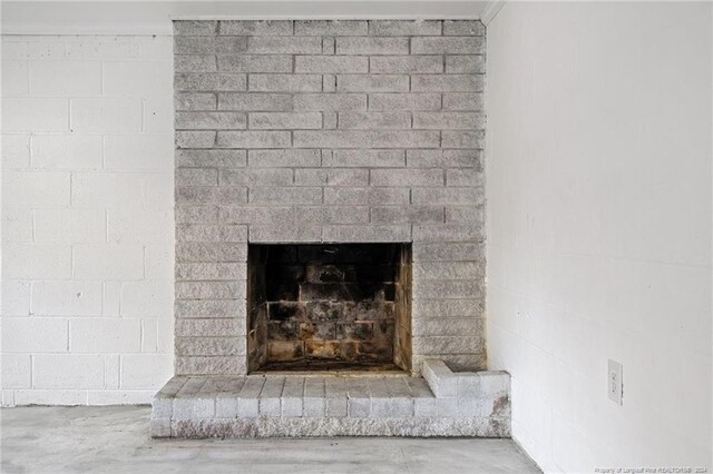 interior details with concrete floors and a brick fireplace