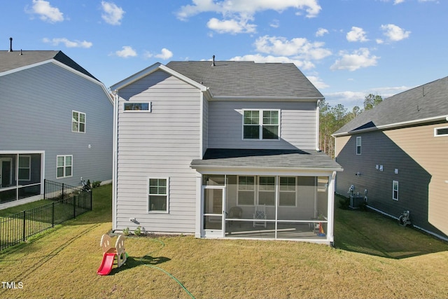 rear view of house with a sunroom, central air condition unit, and a lawn