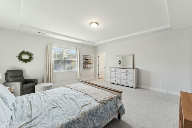 bedroom featuring light carpet and a tray ceiling