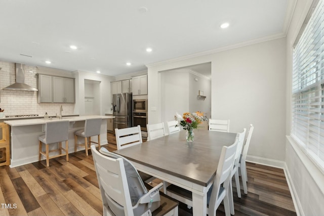 dining area featuring dark hardwood / wood-style floors, ornamental molding, and sink