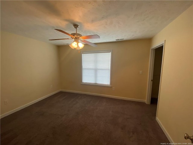 carpeted empty room with ceiling fan and a textured ceiling