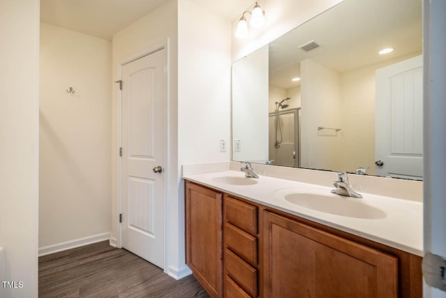 bathroom featuring a shower with door, vanity, and wood-type flooring