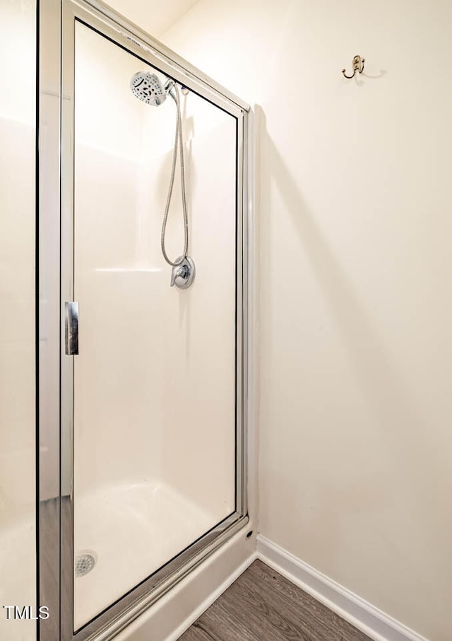 bathroom with hardwood / wood-style floors and an enclosed shower