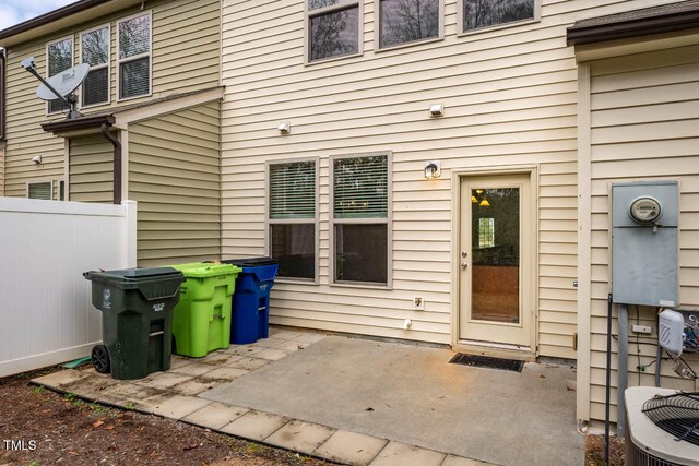 view of exterior entry featuring central AC unit and a patio area