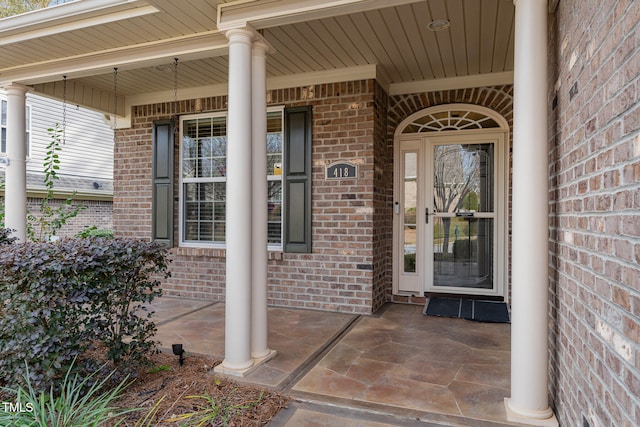 view of exterior entry featuring covered porch